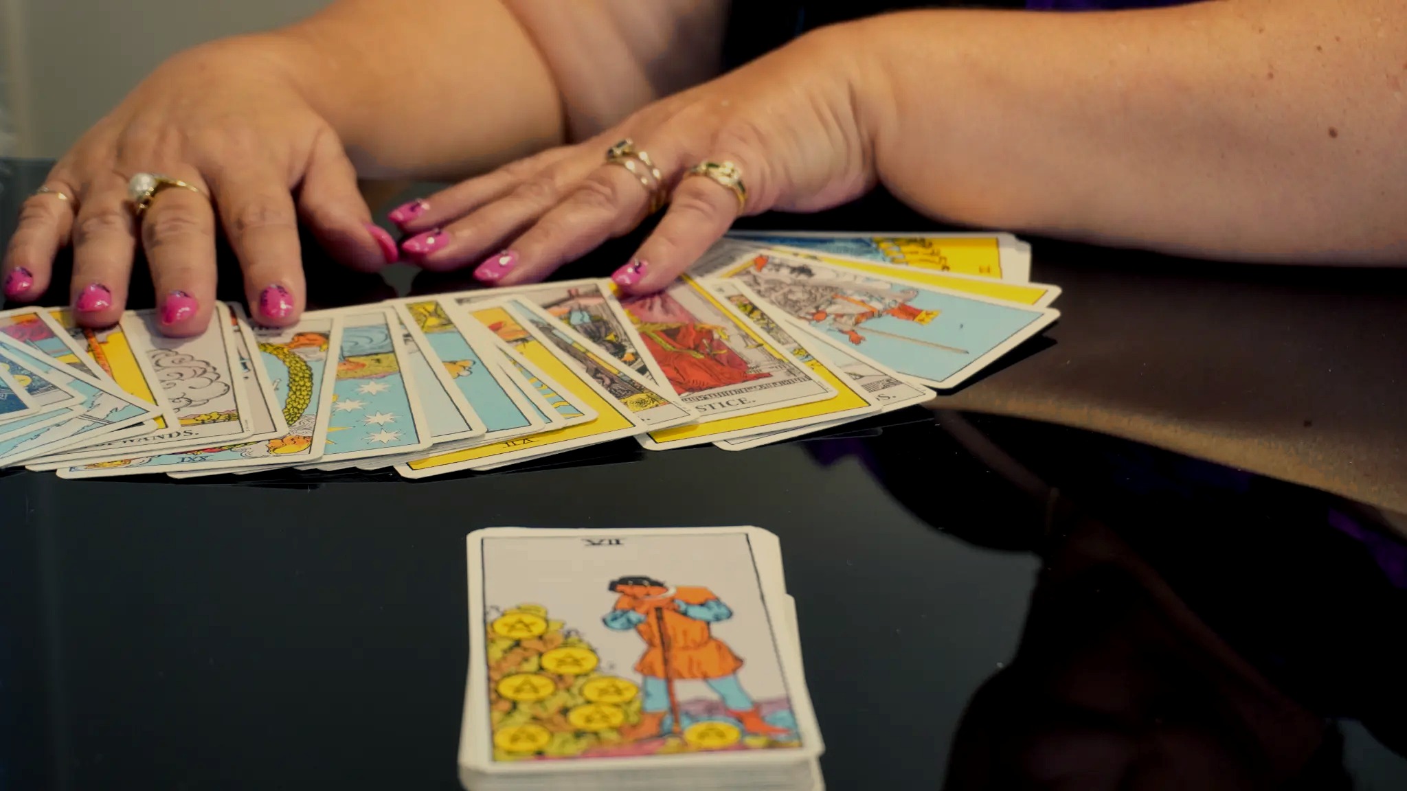 Anne's hands arranging Tarot cards during a reading